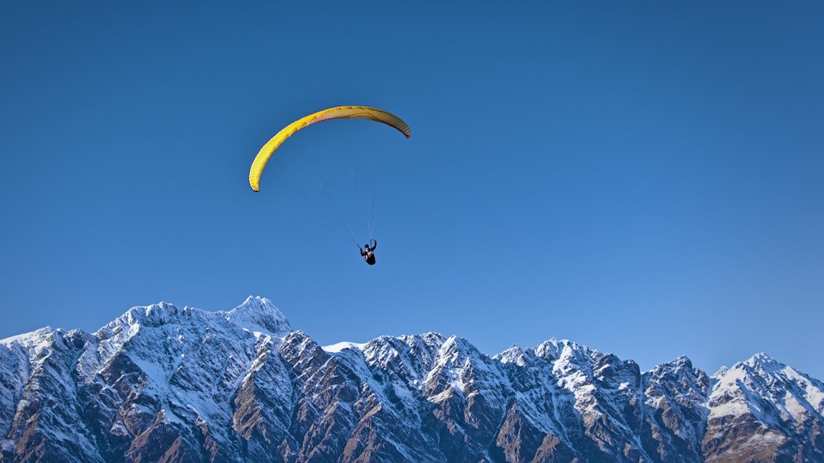 A tandem paraglider in flight above a mountain range — representative image; swap for a real photo of a Sarangkot tandem flight over Pokhara.