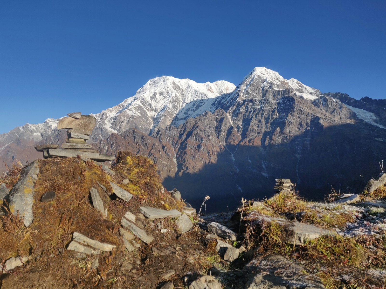 Stone cairn on the Mardi Himal ridge with snow peaks beyond