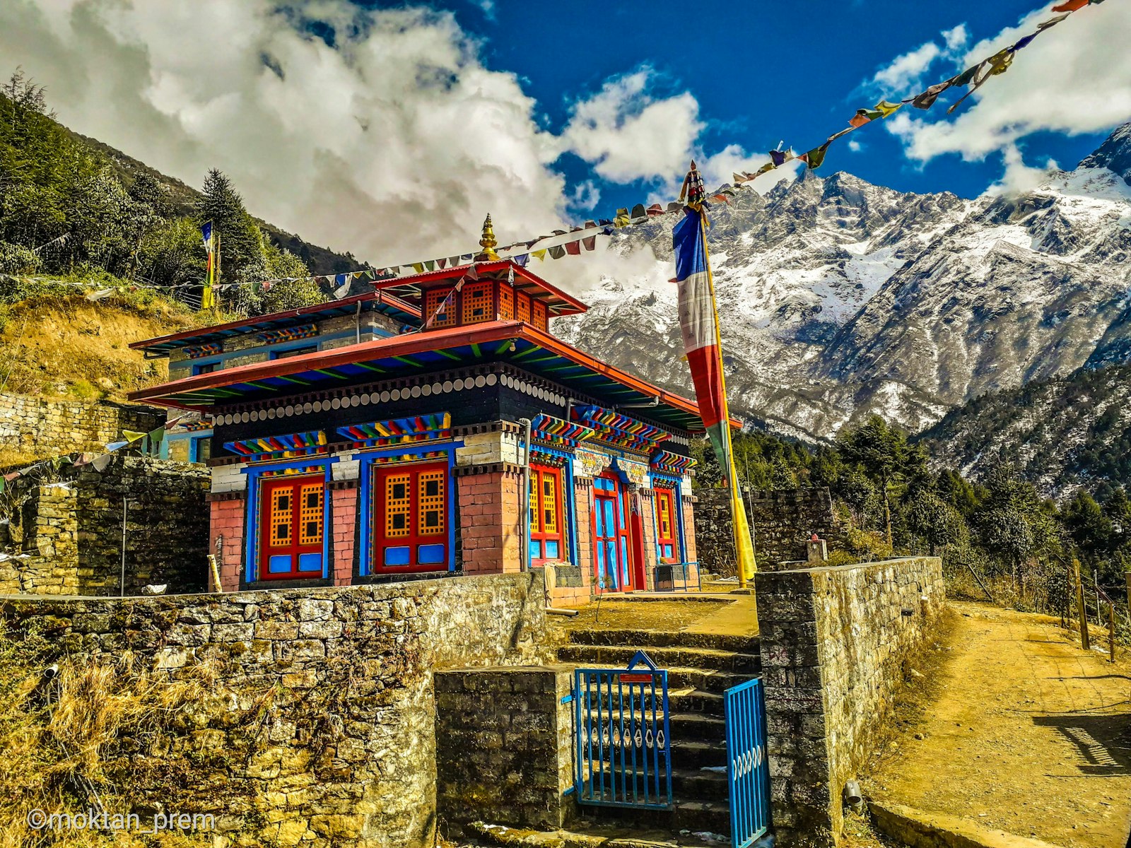 Village teahouses and lodges on a ridge below the snow wall of Annapurna South